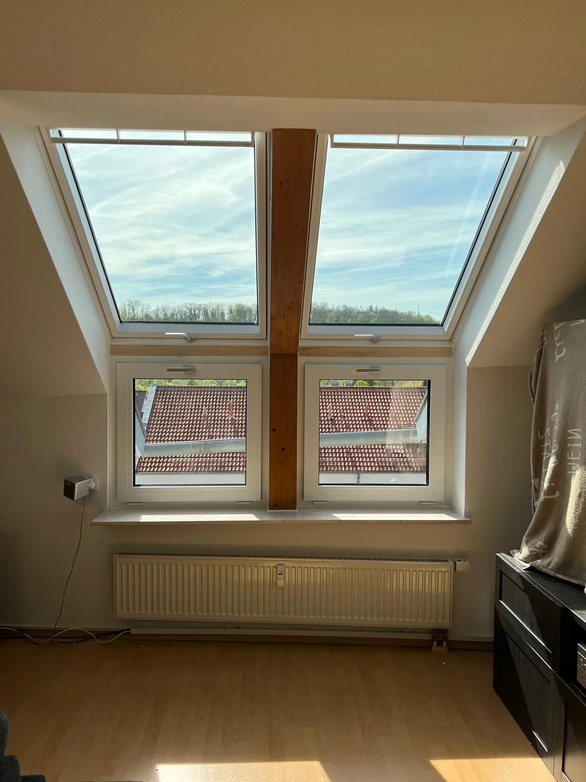 Dachgeschoss mit zwei Dachfenstern und darunterliegenden Fenstern, Blick in den Himmel